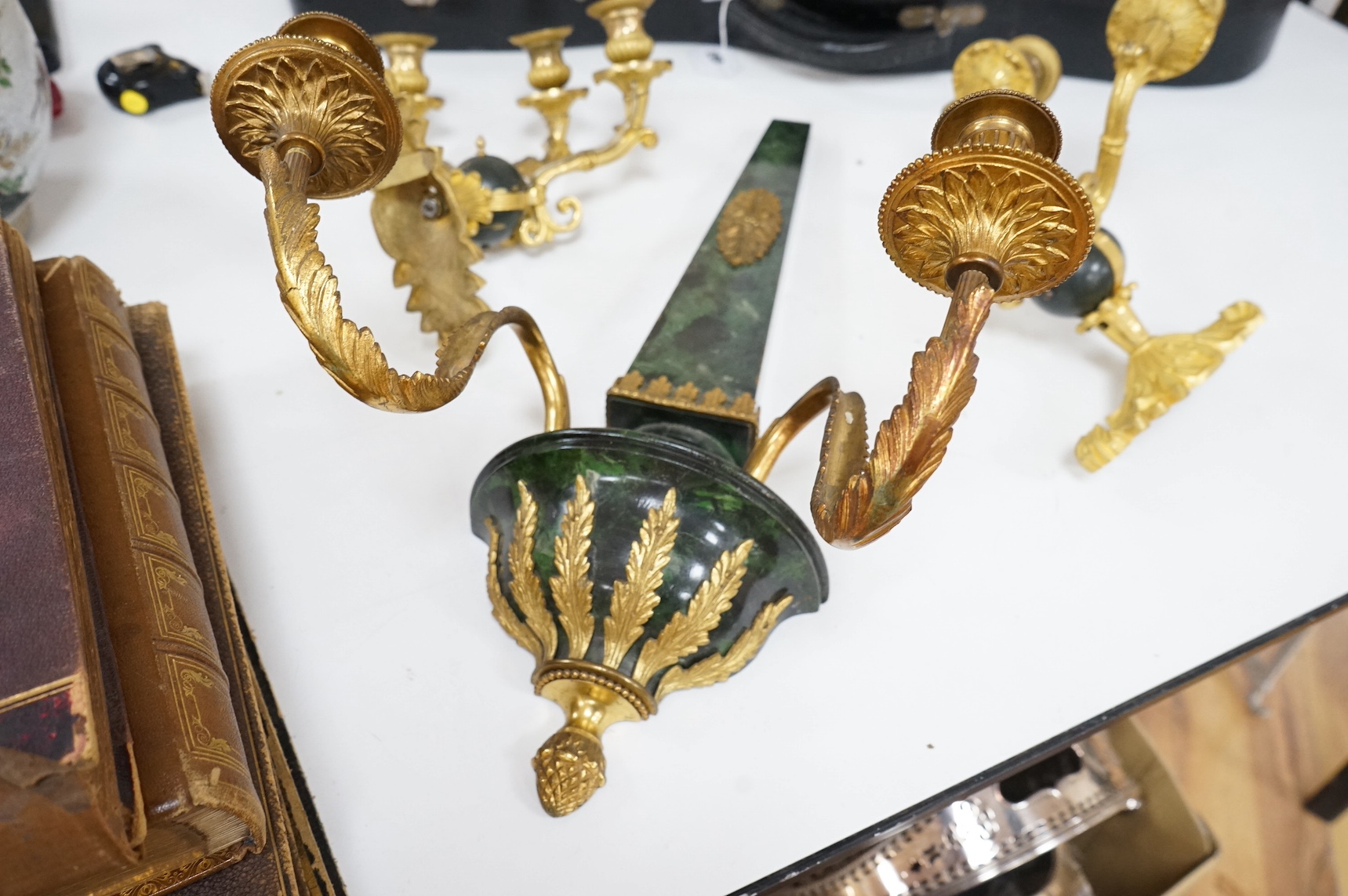 A simulated malachite wall sconce and a pair of ormolu three-branch wall lights, 55cm high. Condition - fair/good